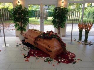 Sarg mit Rosenblättern in der Trauerhalle
